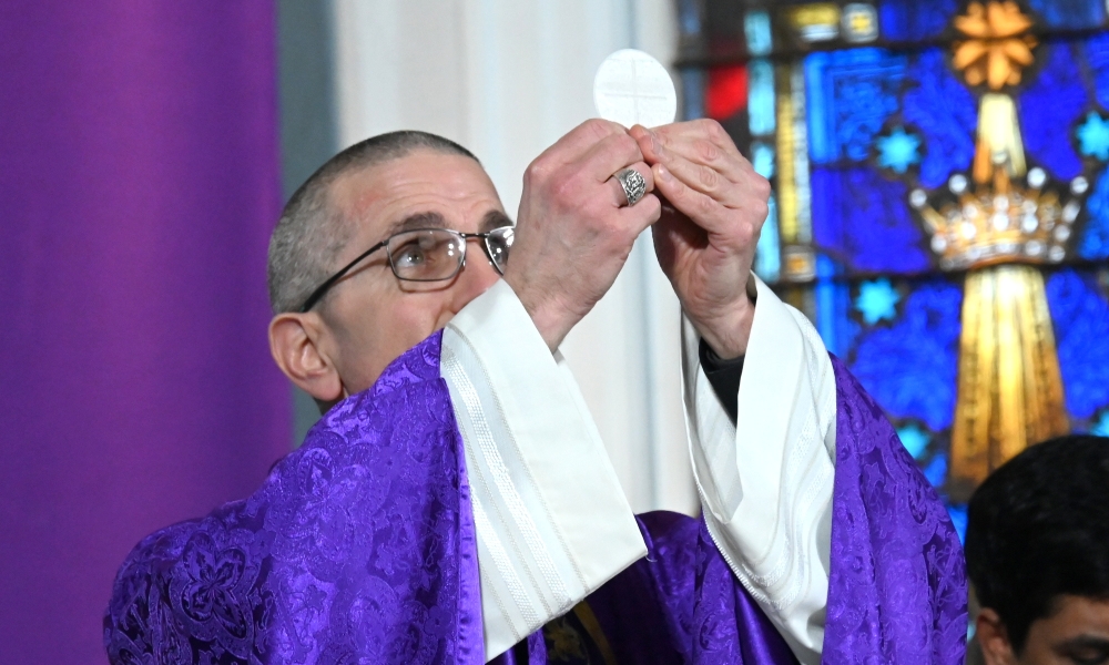 Bishop Ruggieri holding up the Eucharist.